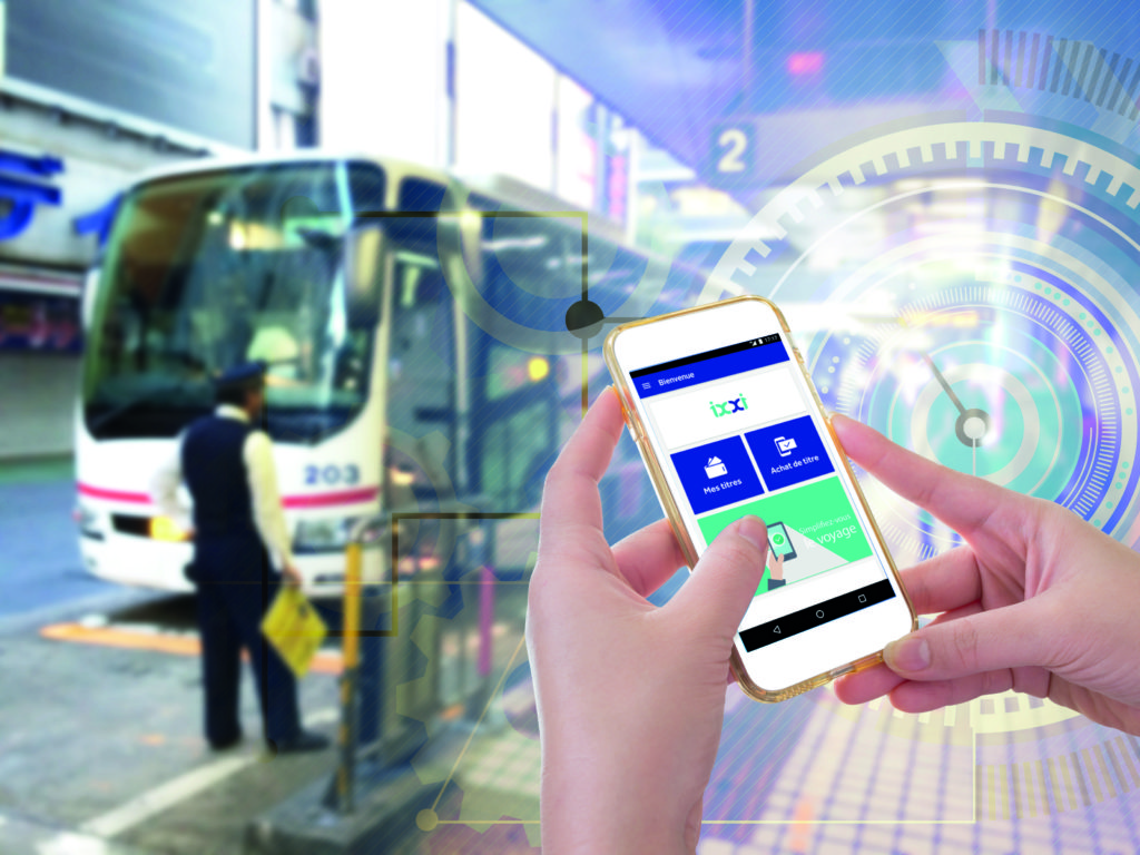 Hand holding mobile phone with E-Ticket word with blur bus terminal  background,Digital Marketing concept; retro color effected